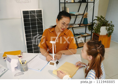 Tutor talking to pupil about sustainable energy sources 111948885