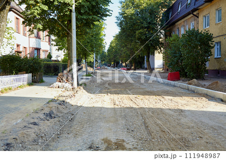 Dirt road with removed asphalt in the city. Construction repair site of road works Dirt road with removed asphalt in the city. Construction repair site of road works 111948987