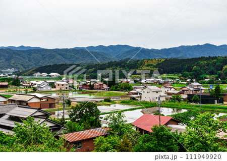 新緑の季節の田舎の風景 田園と街並みと山々 新緑の季節の田舎の風景 田園と街並みと山々 111949920