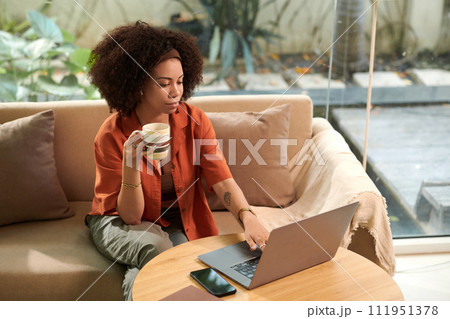 Businesswoman having morning coffee when answering emails from colleagues and customers 111951378