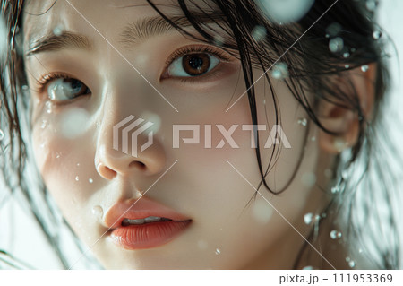 Close up portrait of beautiful young Asian woman with natural makeup and water splash on her face 111953369
