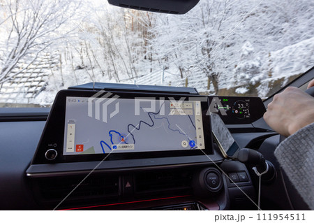 雪の道路を走行している自動車の運転席 111954511