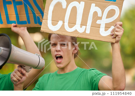 Portrait of eco-volunteer showing placard and shouting in loudspeaker Portrait of eco-volunteer showing placard and shouting in loudspeaker 111954840