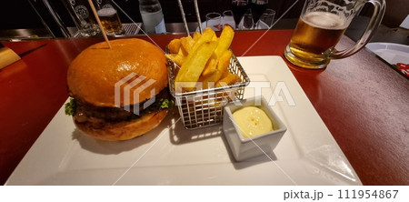 Gourmet burger and fries with beer on table Gourmet burger and fries with beer on table 111954867