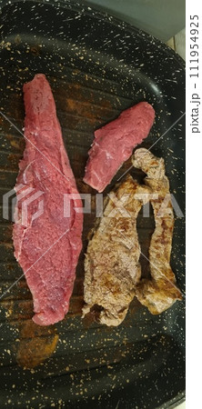 Raw and cooked steak assortment in pan. Vertical image Raw and cooked steak assortment in pan. Vertical image 111954925