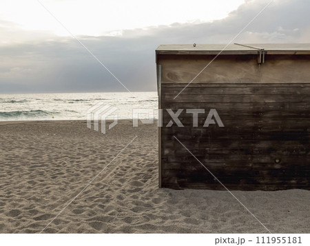 A solitary wooden cabin door stands on a tranquil beach, A solitary wooden cabin door stands on a tranquil beach, 111955181