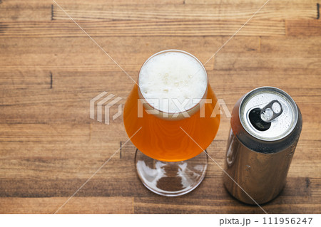 Craft beer glass with open can on wooden table Craft beer glass with open can on wooden table 111956247