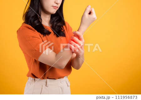 Isolated portrait of a girl touching her wrist in discomfort. Illustrating pain and inflammation due to injury. Isolated portrait of a girl touching her wrist in discomfort. Illustrating pain and inflammation due to injury. 111956873