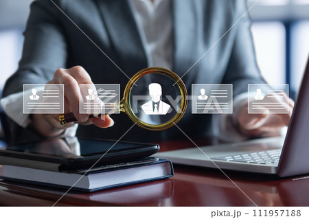 Businesswoman searches for a candidate while studying a resume . Businesswoman searches for a candidate while studying a resume . 111957188