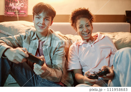 Portrait of two teenage friends playing videogames together with console and having fun 111958683