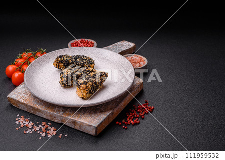 Delicious fresh crispy chicken or fish nuggets on a dark concrete background Delicious fresh crispy chicken or fish nuggets on a dark concrete background 111959532