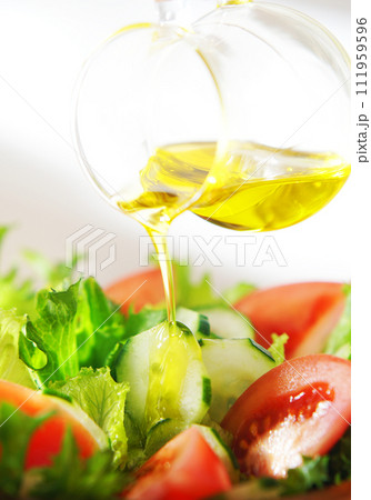 レタスとトマトのサラダにオリーブオイルをかける 111959596
