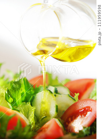 レタスとトマトのサラダにオリーブオイルをかける 111959598