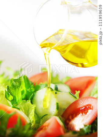 レタスとトマトのサラダにオリーブオイルをかける 111959639