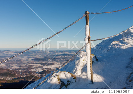 Winter morning, danger path from Snezka to Silesian house, krkonose mountains. The path is secured with a railing of chains. Winter morning, danger path from Snezka to Silesian house, krkonose mountains. The path is secured with a railing of chains. 111962097
