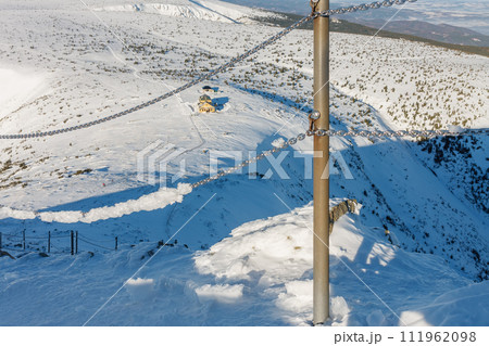 Winter morning, danger path from Snezka to Silesian house, krkonose mountains. The path is secured with a railing of chains. Winter morning, danger path from Snezka to Silesian house, krkonose mountains. The path is secured with a railing of chains. 111962098