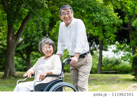 車椅子で散歩するシニア夫婦 111962301