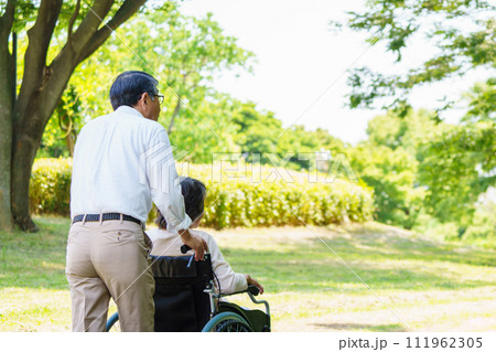 車椅子で散歩するシニア夫婦 111962305