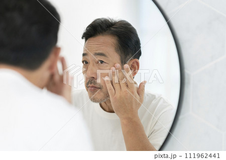 鏡を見て考えこむ中年男性 111962441