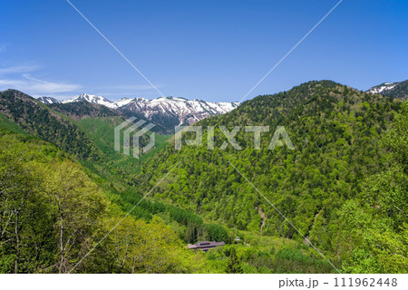 上高地乗鞍スーパー林道より望む残雪の乗鞍岳と新緑の白骨温泉 上高地乗鞍スーパー林道より望む残雪の乗鞍岳と新緑の白骨温泉 111962448