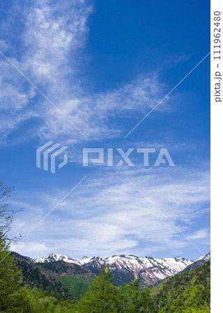 上高地乗鞍スーパー林道より望む残雪の乗鞍岳と新緑の山並み 上高地乗鞍スーパー林道より望む残雪の乗鞍岳と新緑の山並み 111962480