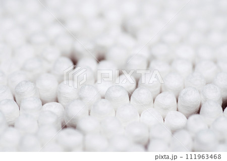 Many white cotton sticks. Round container with cotton buds Many white cotton sticks. Round container with cotton buds 111963468