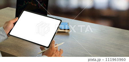 A businessman holds a mockup. digital tablet with blank screen Mockup replaces your design mockup in the office. 111963960