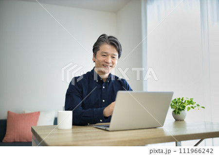 リビングでテレワークをするミドル男性 111966242