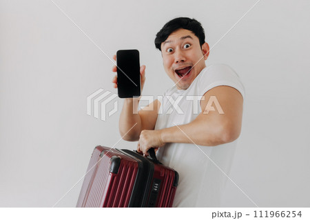 Surprise and wow face of Asian man holding up a suitcase and showing the mobile phone application display. Surprise and wow face of Asian man holding up a suitcase and showing the mobile phone application display. 111966254