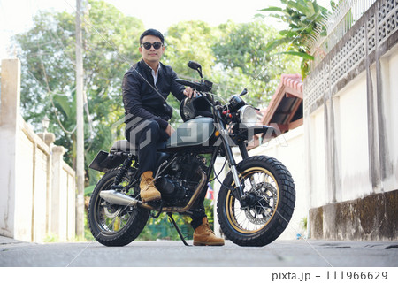 Asian man motorbike in black leather jacket travel rider trip. Handsome Men wear sunglass outdoor lifestyle freedom rider. Men trendy hipster cool person. Young asian man hobby ride with motor bike Asian man motorbike in black leather jacket travel rider trip. Handsome Men wear sunglass outdoor lifestyle freedom rider. Men trendy hipster cool person. Young asian man hobby ride with motor bike 111966629