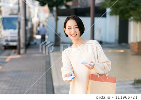 街頭でポケットティッシュを配る女性 111966721