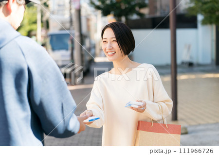 街頭でポケットティッシュを配る女性 111966726