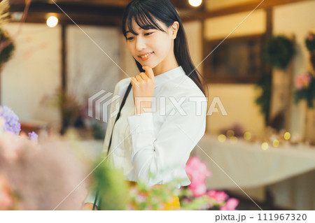花屋にお花を買いに来た女性 111967320