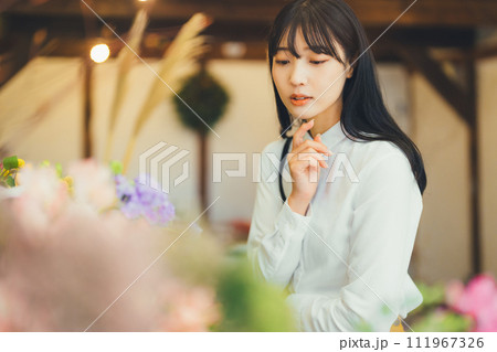 花屋にお花を買いに来た女性 111967326