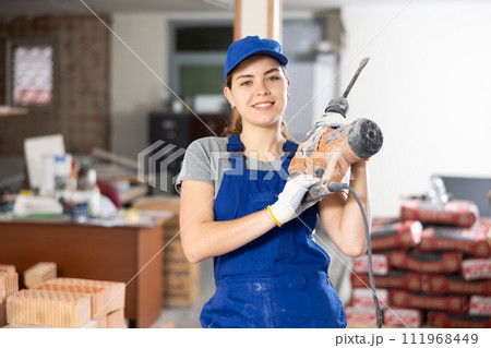 Portrait of woman engineer holding electric hammer 111968449