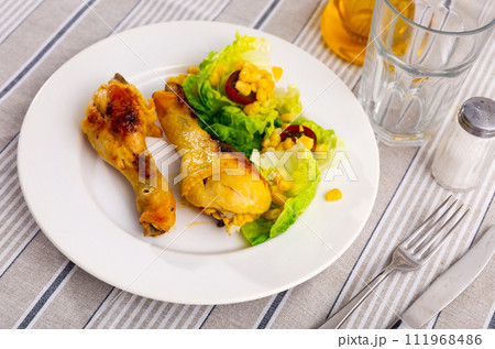 Roasted chicken pieces with salad of lettuce and corn 111968486
