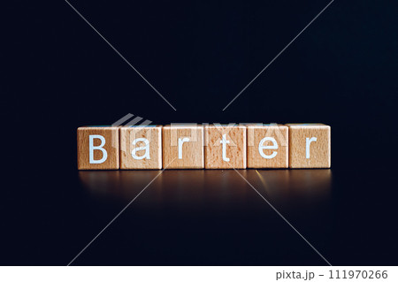 Wooden blocks form the text "Barter" against a black background. Wooden blocks form the text "Barter" against a black background. 111970266
