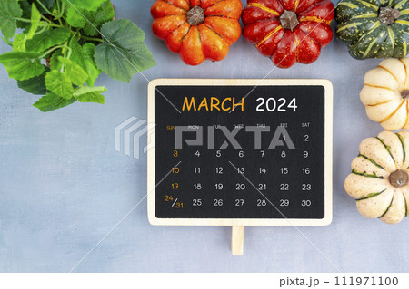 View from above to simple March 2024 calendar decorated with pumpkin. View from above to simple March 2024 calendar decorated with pumpkin. 111971100