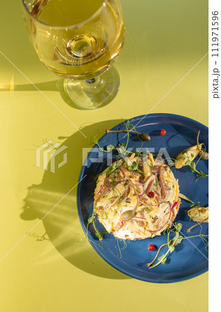 Seafood salad with white wine on blue plate, perfect for a refreshing meal. Seafood salad with white wine on blue plate, perfect for a refreshing meal. 111971596