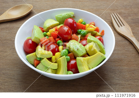 close up view of avocado salad with sesame soy sauce in a bowl on wooden table. homemade style healthy food concept. 111971916