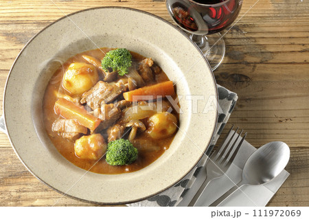 ブロッコリーや人参、しめじなど沢山の具材が入っている熱々ビーフシチューと赤ワイン 111972069