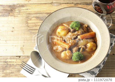 ブロッコリーや人参、しめじなど沢山の具材が入っている熱々ビーフシチューと赤ワイン 111972070