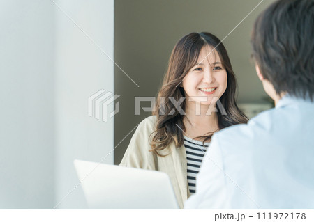 診察を受ける患者の女性と話を聞く医師・医者(回復・寛解・根治・完治・笑顔) 診察を受ける患者の女性と話を聞く医師・医者(回復・寛解・根治・完治・笑顔) 111972178