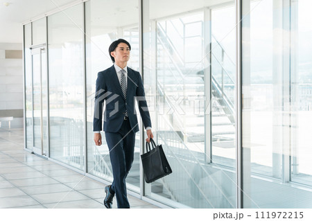 会社・オフィスに出勤・出社・通勤する若い男性アジア人ビジネスマン 111972215