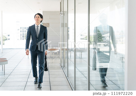 会社・オフィスに出勤・出社・通勤する若い男性アジア人ビジネスマン 会社・オフィスに出勤・出社・通勤する若い男性アジア人ビジネスマン 111972220