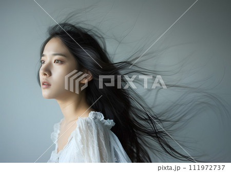 風に舞う髪を持つ神秘的な表情のアジア人女性 風に舞う髪を持つ神秘的な表情のアジア人女性 111972737