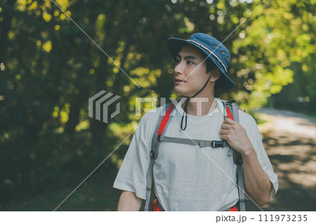 リュックを背負って林道を歩く男性 111973235