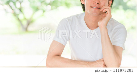 新緑の背景にいる白Tシャツ姿のさわやかな男性 新緑の背景にいる白Tシャツ姿のさわやかな男性 111973293