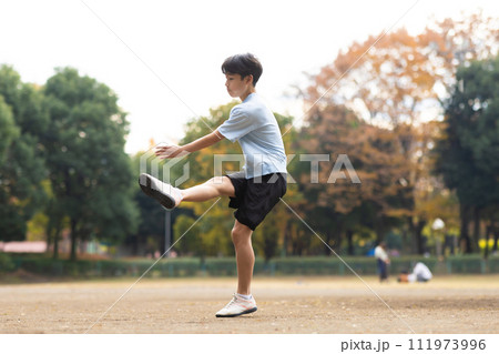 公園でサッカーを楽しむ小学生男子 111973996