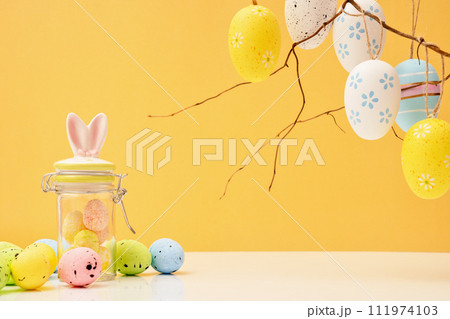 Happy Easter concept with eggs and jar bunnies with sweets and candies. Egg hunt with twigs. Copy space Happy Easter concept with eggs and jar bunnies with sweets and candies. Egg hunt with twigs. Copy space 111974103
